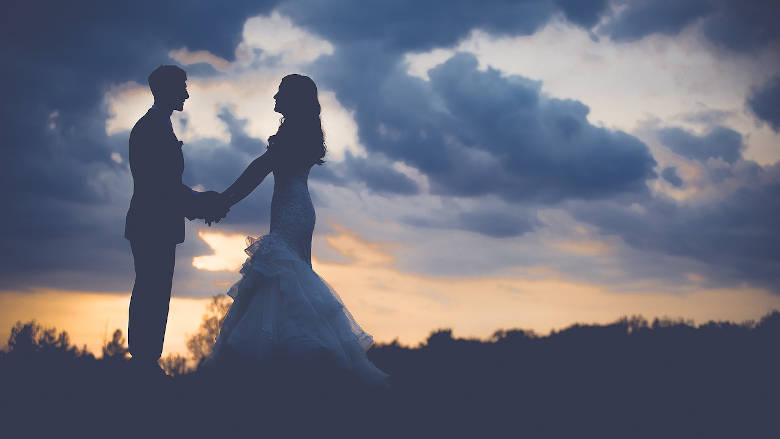 Bride and Groom holding hands at sunset in the mountains